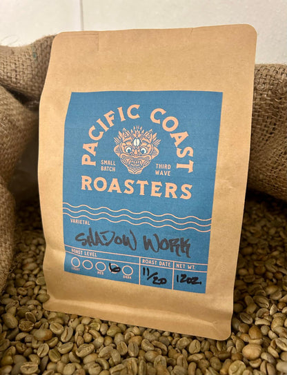 Coffee bag from Pacific Coast Roasters on a bed of coffee beans
